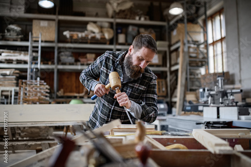 Portrait of mature male carpenter working on his product. Small business concept.