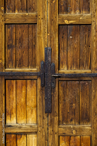 Bild auf Leinwand Old weathered wooden door with iron hinges and handle