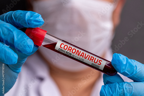 Doctor with blood sample of Covid-19 Omicron B.1.1.529 Variant and general data of covid-19 Coronavirus Mutations. photo