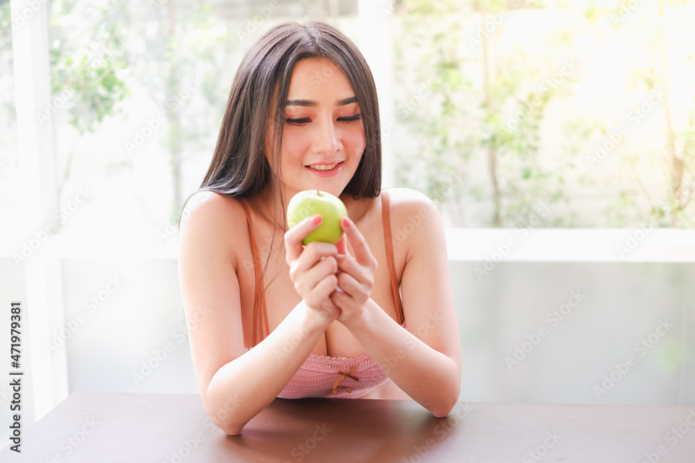 Portrait sexy asian woman wear lingerie or underwear with green apple holding in hand, healthy diet concept Portrait sexy asian woman wear lingerie or underwear with green apple holding in hand, healthy diet concept