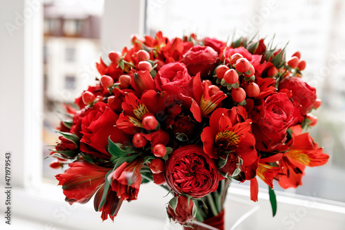 Wedding flowers, red color, bridal bouquet closeup. Decoration made of roses, hypericum and decorative plants, close-up, selective focus, nobody