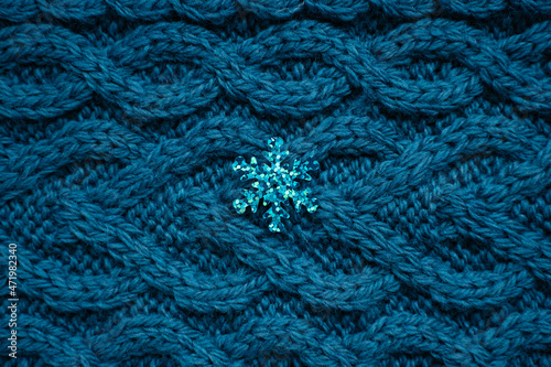 teal blue knit sweater background with blue snowflake