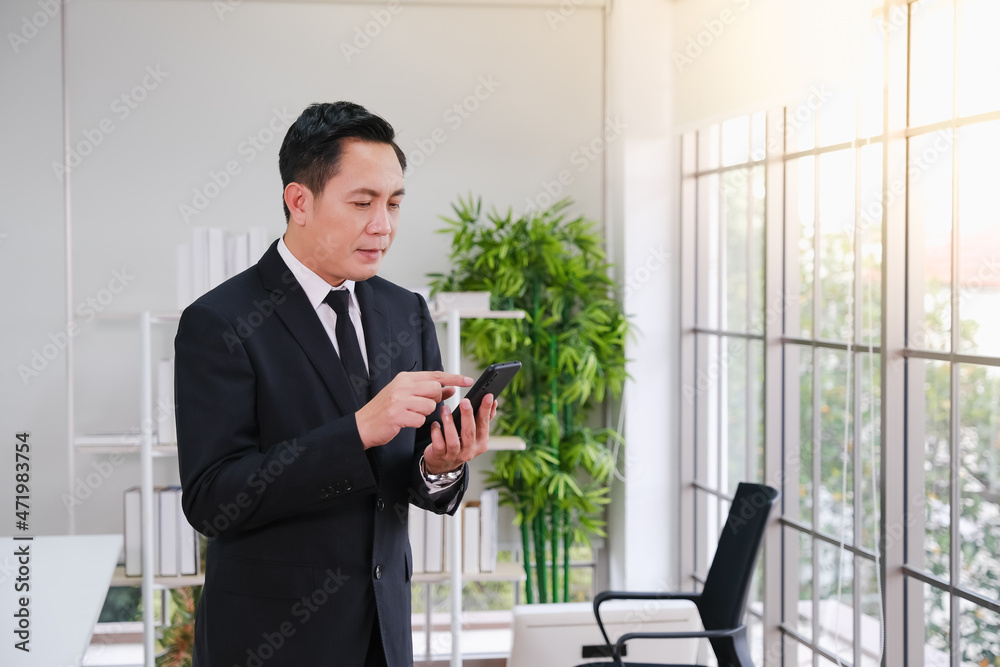 Asia businessman talking smart phone in co working space or office or workplace Asia businessman talking smart phone in co working space or office or workplace