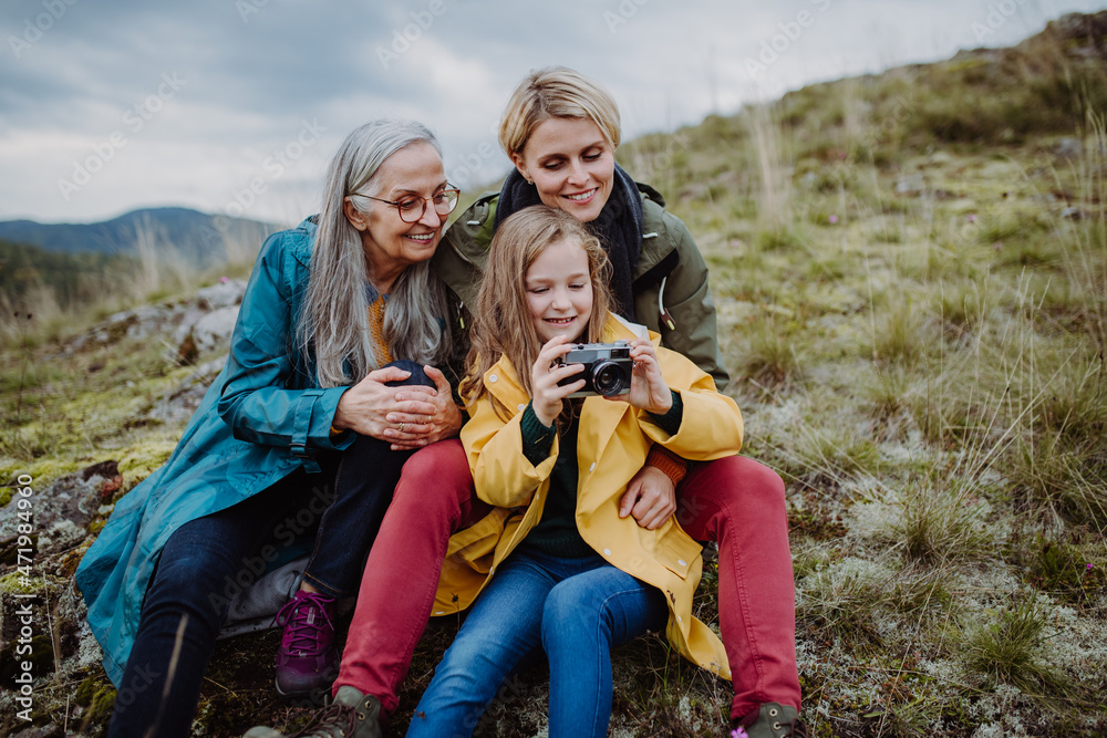 Small girl with mother and grandmother taking selfie pictures on top of mountain. Small girl with mother and grandmother taking selfie pictures on top of mountain.
