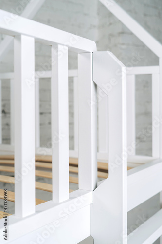 The image of the grates child's bed against the backdrop of the white wall.