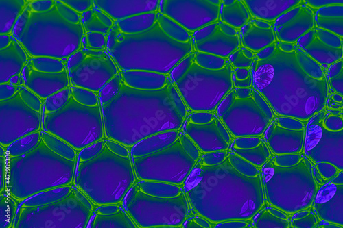 Blue and neon green oil or serum background with bubbles.