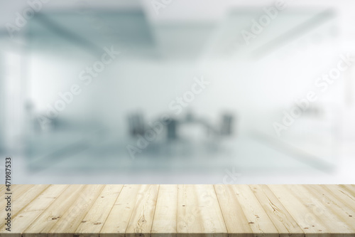 Blank wooden office desk with light furnished meeting room on background, mock up © Pixels Hunter