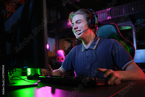 Professional young caucasian gamer playing online on his PC. He upset because of losing the game