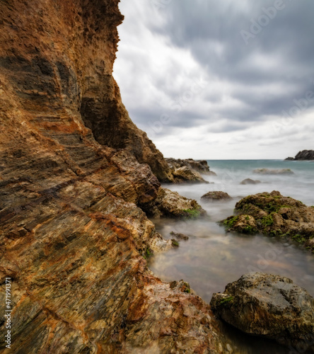 Cliff on the left with the Mediterranean Sea and a sky covered with clouds. Cabo de Palos(Murcia-Spain)