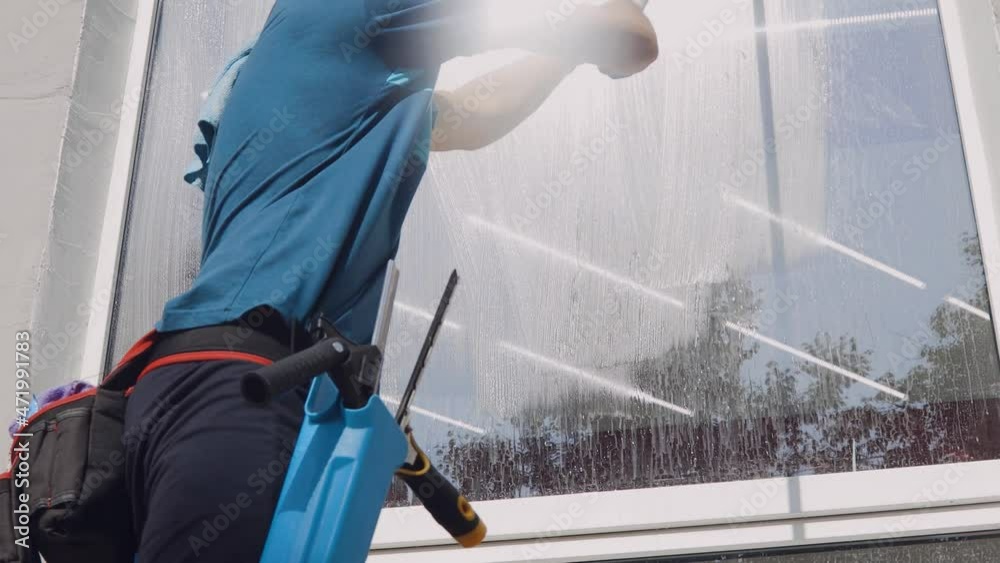 A professional cleaning service worker washes the windows with special foam and cleans them.