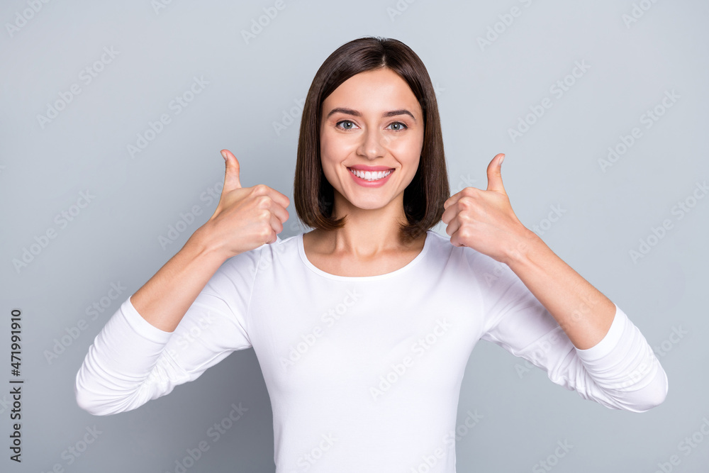 Photo of cool brunette young lady show thumb up wear white jumper isolated on grey color background Photo of cool brunette young lady show thumb up wear white jumper isolated on grey color background