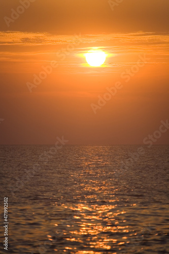 Fototapeta Naklejka Na Ścianę i Meble -  The evening sun sinks to the sea horizon.