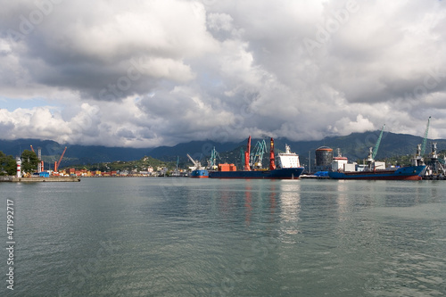 Ships are in the port on the pier against the backdrop of the mountains.