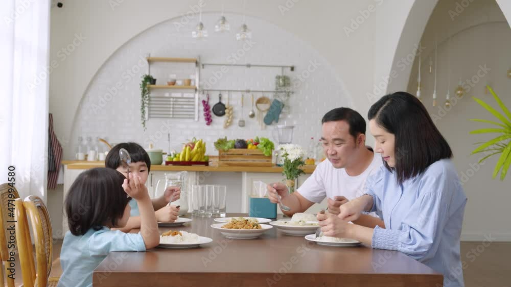 A happy Asian family has lunch together at a table...Father, mother, and son's connection and activities in the house