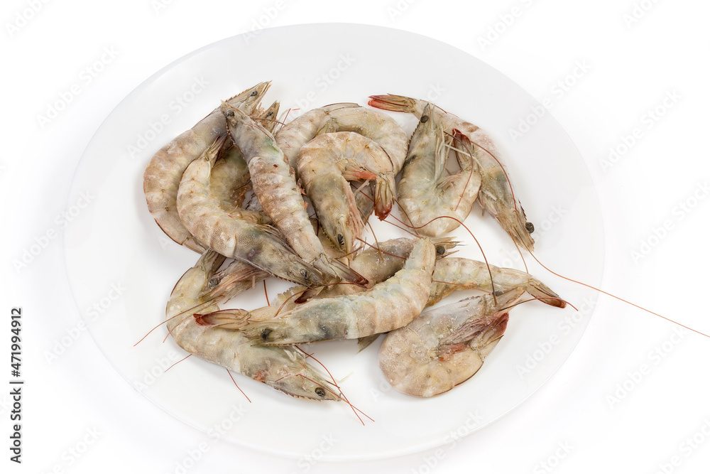 Frozen king prawns on dish on white background close-up