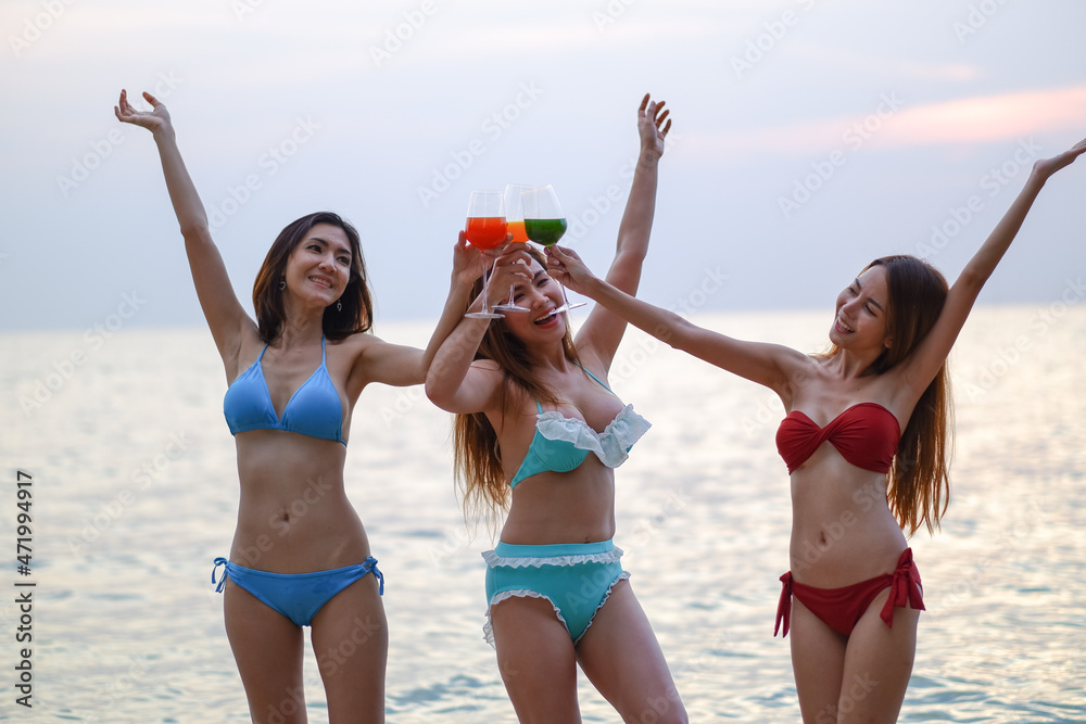 Portrait asia girls wearing swimsuit in seaside happy on the beach, sexy bikini couple ladies