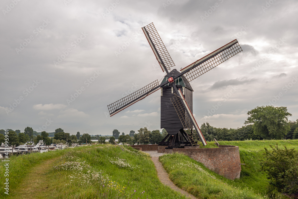 Obraz premium Windmill on the ramparts of the fortified town of Heusden in the Dutch province of North Brabant. The photo was taken on a cloudy day in the spring season.
