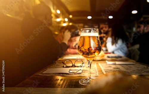 Group of people having lunch at brewery bar restaurant - Close up glass beer on dining table - Brewery and food concept