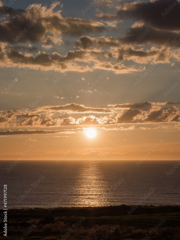 Sunrise view on the coast with the sun and clouds in the background