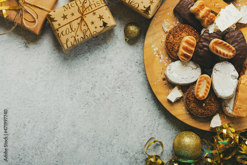 Top view of nougat christmas sweet,mantecados and polvorones with christmas ornaments and copy space. Assortment of christmas sweets typical in Spain. Selective focus photo