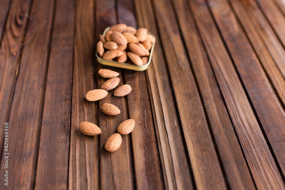 almonds in a bowl on a wooden background almonds in a bowl on a wooden background