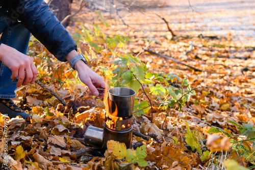 Cooking tea over an open fire in autumn forest
