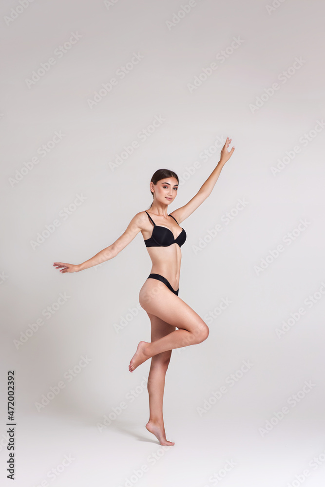 Fototapeta premium beautiful woman with perfect body in black underwear jumping