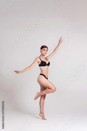beautiful woman with perfect body in black underwear jumping