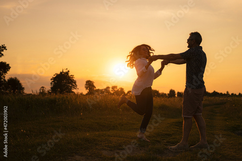Beautiful middle-aged couple having fun in nature. Happiness and love at sunset