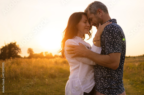 Beautiful middle-aged couple in nature. Romance and love at sunset