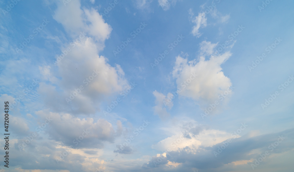 Clear blue sky with white fluffy clouds at noon. Day time. Abstract nature landscape background.