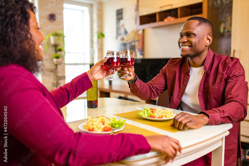 african american couple in love drinking wine from glasses and eating italian pasta in living room 14 february valentines day