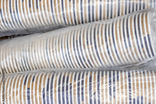 Wallpaper Mural lot of paper cups in a row one over another in cellophane pack in a cardboard brown box.stack of cups for coffee machine. tea, americano, espresso, cappuccino, hot chocolate.coffee business paper eco  Torontodigital.ca