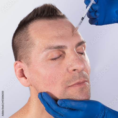 Plastic surgery concept. Man receiving injection in his face. Trendy cosmetics procedure for men