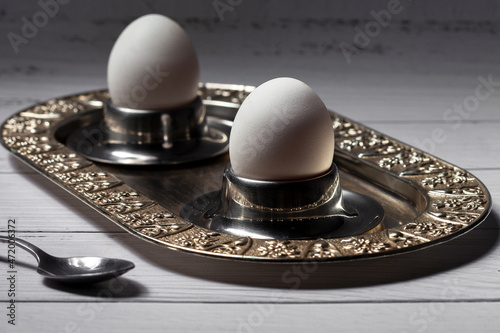 Obraz na plátně Boiled egg in an egg cup on an old metal breakfast tray