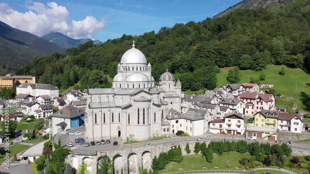 Picturesque summer view from drone of alpine township of Re with pilgrimage church of Virgin Mary surrounded by green Alps, Piedmont, Italy
