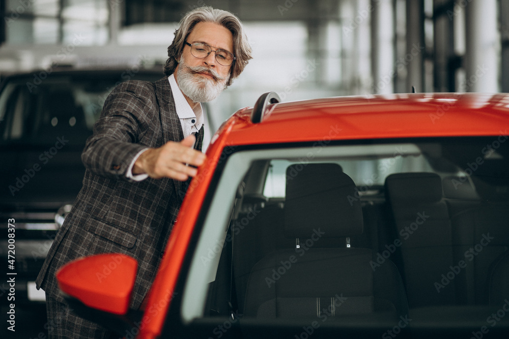Business man looking for a car in a car salon Business man looking for a car in a car salon