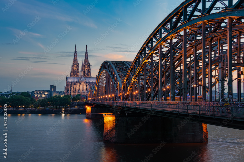 Fototapeta premium Kölner Dom mit Hohenzollernbrücke zum Sonnenuntergang