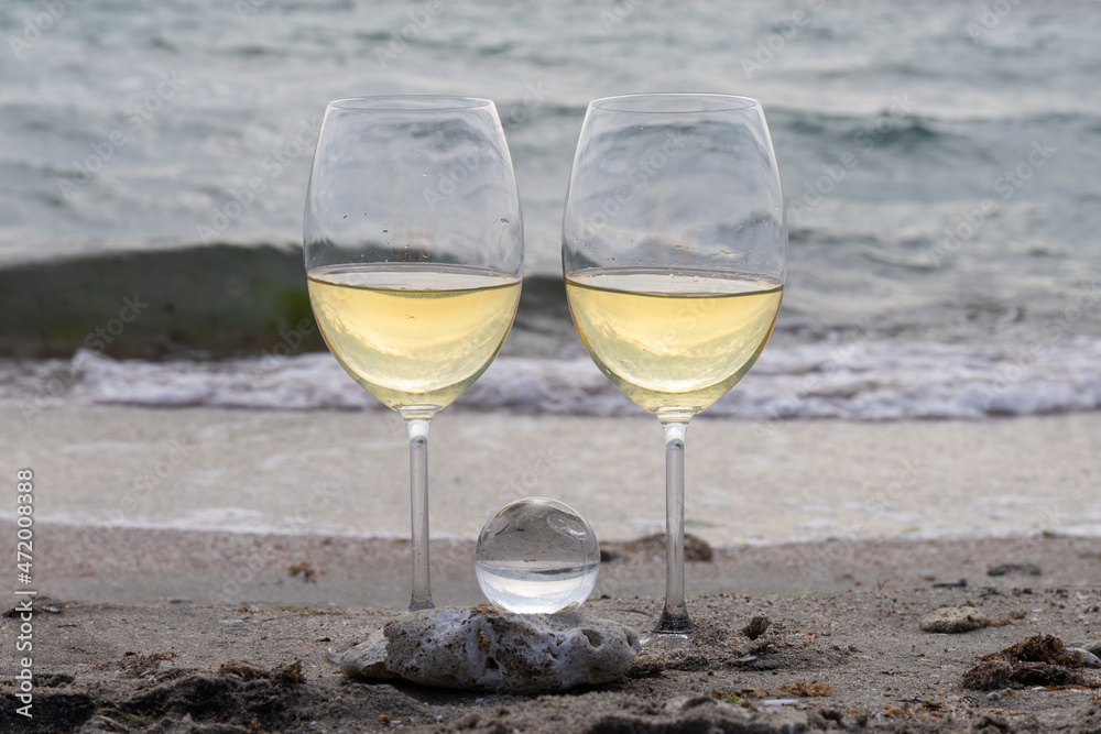 Romantic glass of white wine, on the sea beach. Wine tasting and relaxation at the resort Romantic glass of white wine, on the sea beach. Wine tasting and relaxation at the resort
