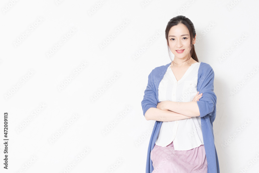 白い壁の前で椅子に座っている主婦 白い壁の前で椅子に座っている主婦