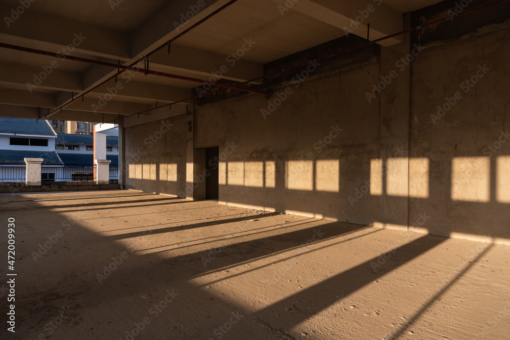 Sunlight shines on the unfinished indoor concrete wall
