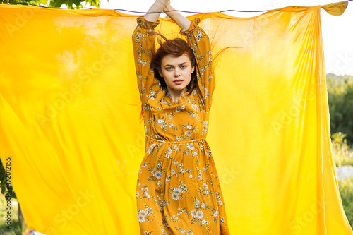 smiling woman in yellow dress posing nature yellow cloth