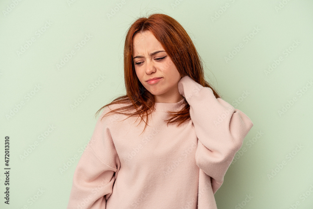 Young caucasian woman isolated on green background having a neck pain due to stress, massaging and touching it with hand. Young caucasian woman isolated on green background having a neck pain due to stress, massaging and touching it with hand.