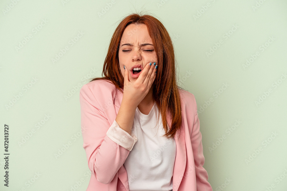 Young caucasian woman isolated on green background having a strong teeth pain, molar ache. Young caucasian woman isolated on green background having a strong teeth pain, molar ache.