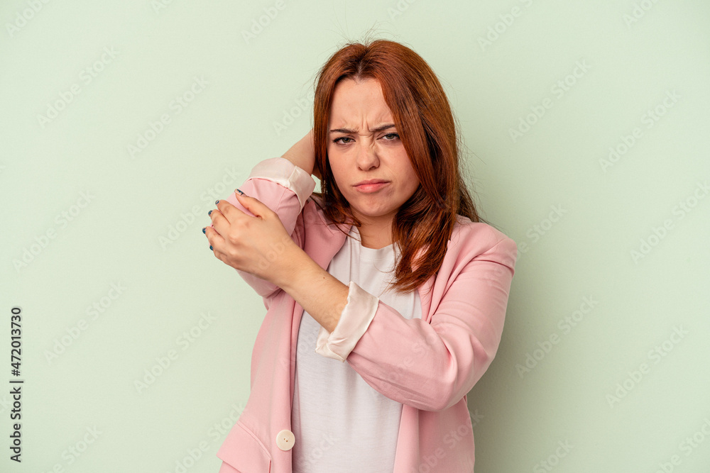 Young caucasian woman isolated on green background having a neck pain due to stress, massaging and touching it with hand. Young caucasian woman isolated on green background having a neck pain due to stress, massaging and touching it with hand.