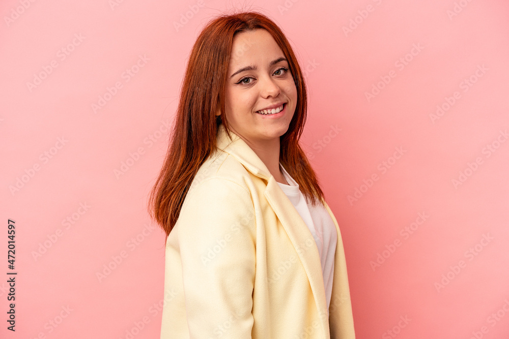 Young caucasian woman isolated on pink background confident keeping hands on hips.