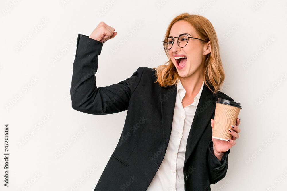 Young business caucasian woman holding take away coffee isolated on white background raising fist after a victory, winner concept.