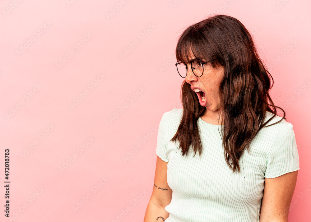 Young Argentinian woman isolated on pink background shouting very angry, rage concept, frustrated. Young Argentinian woman isolated on pink background shouting very angry, rage concept, frustrated.