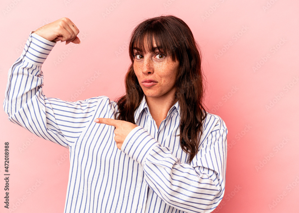 Young Argentinian woman isolated on pink background showing strength gesture with arms, symbol of feminine power Young Argentinian woman isolated on pink background showing strength gesture with arms, symbol of feminine power