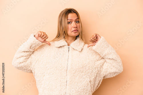 Young caucasian woman isolated on beige background feels proud and self confident, example to follow.